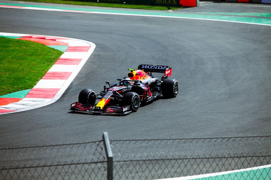 Dynamic race action at Spa-Francorchamps, showing McLaren and Ferrari challenging Red Bull.