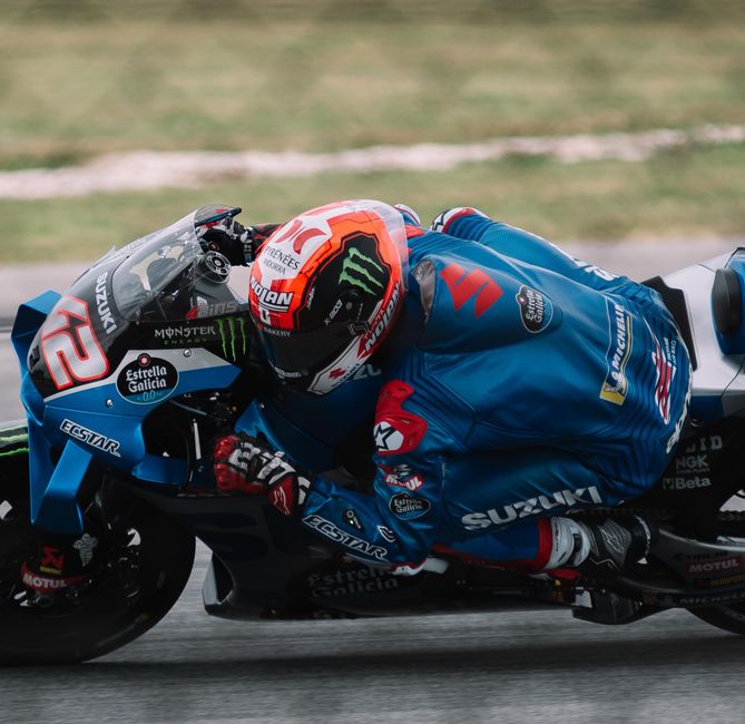 Wide shot capturing speed blur of Bulega on Ducati, tyre marks visible, 2026 race