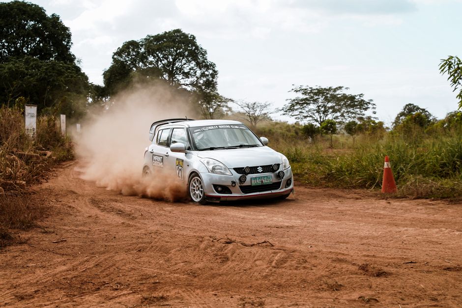 Close-up podium Rally Kenya, jejak ban, dan kecepatan buram