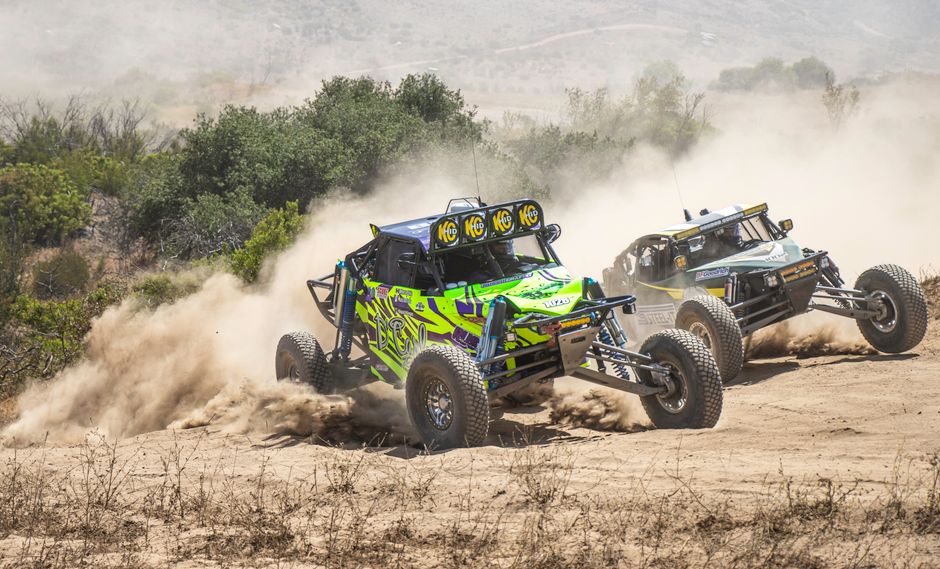 Action shot of rally cars racing through rugged terrain, dramatic angles, dust trails, 2026 season