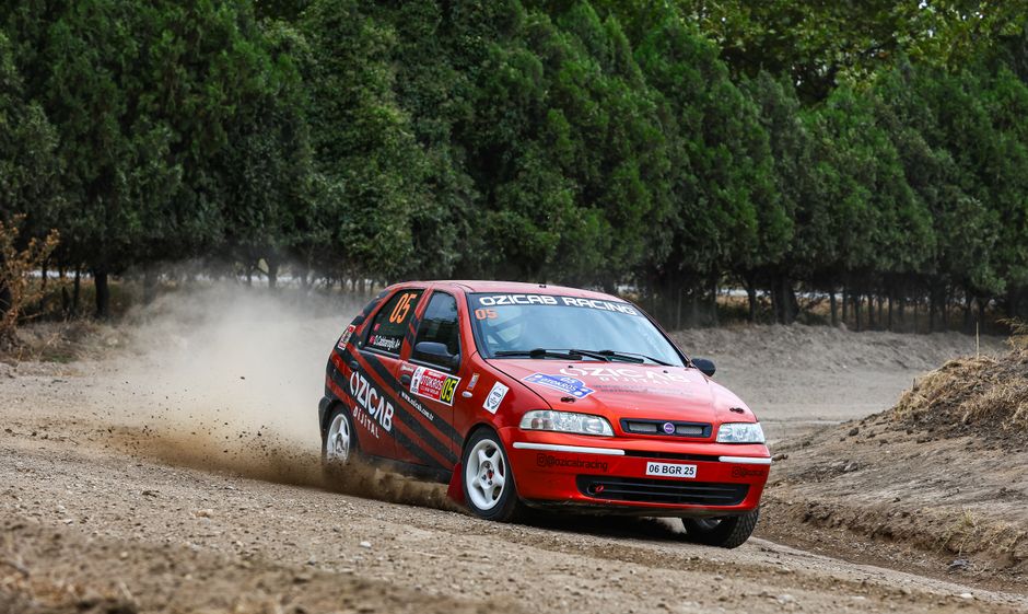 Close-up of rally car on podium, tire marks on dirt track, speed blur effect